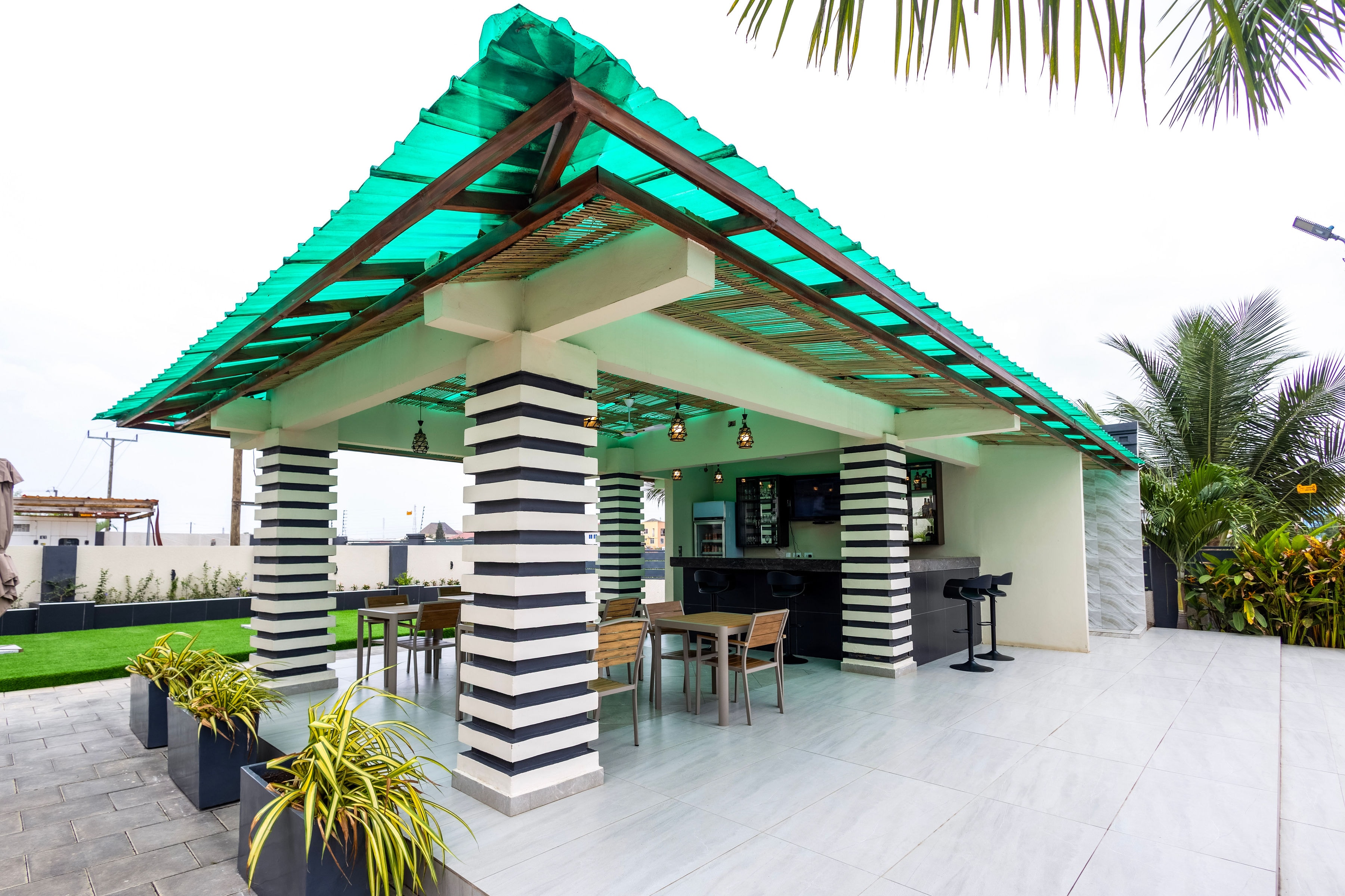 The open-sided poolside bar pavilion with its green pitched roof