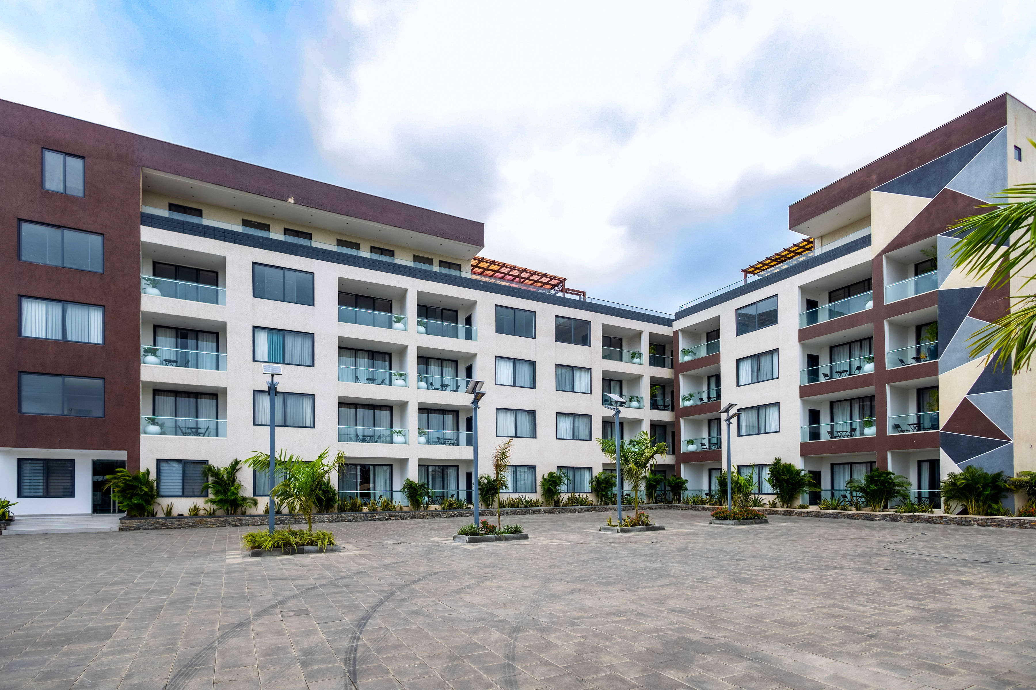 The apartment blocks around the paved central courtyard on a bright day