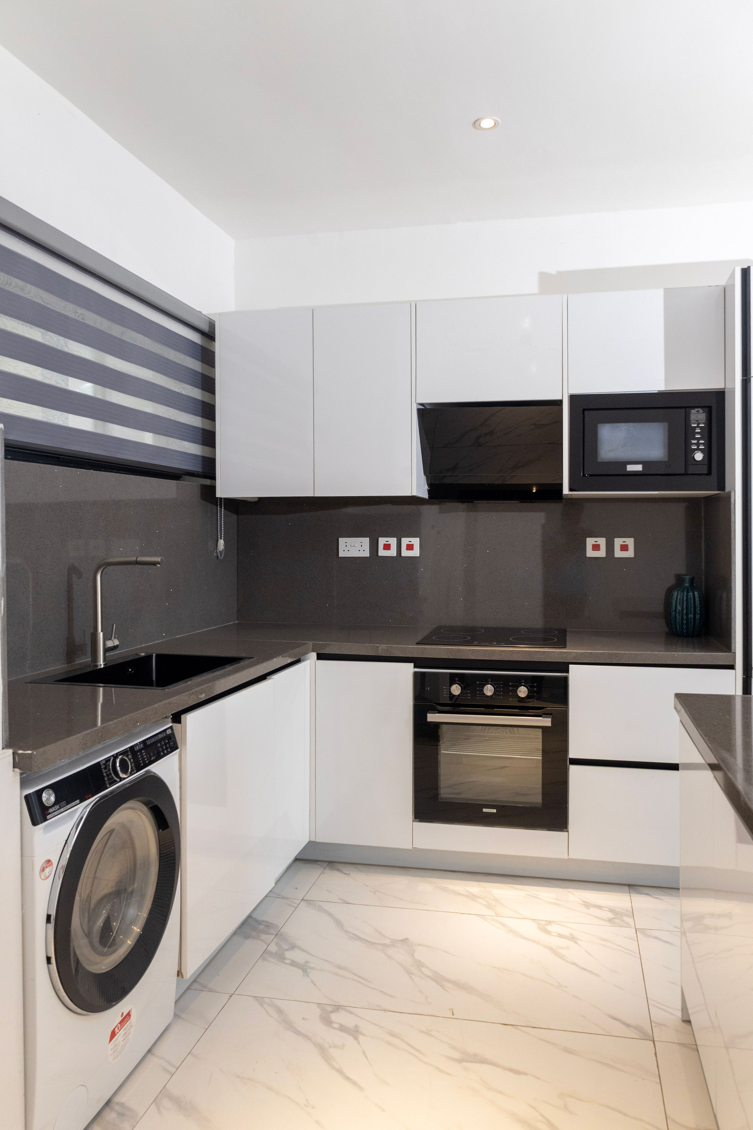 Two-bedroom fitted kitchen with an oven, hob, microwave and washing machine